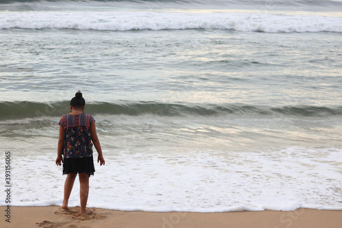woman walking on the beach. girl looking the sea. Lonely girl at the seashore. Indian girl watching the sea. Girl at the beach.