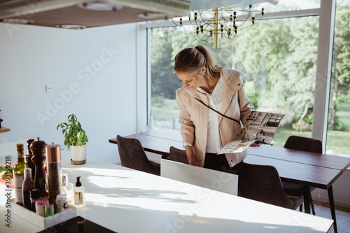 Woman with magazine examining dining furniture at new property photo