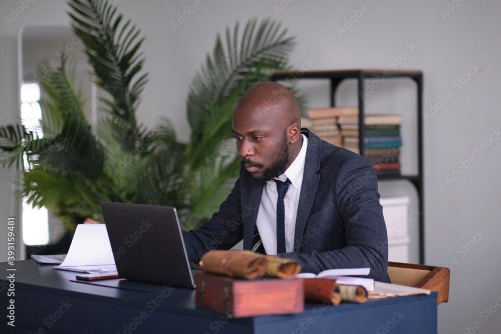 Thoughtful serious mixed race business analyst working with marketing statistics. pensive young african american international company employee manager working with hard task at workplace. soft focus Thoughtful serious mixed race business analyst working with marketing statistics. pensive young african american international company employee manager working with hard task at workplace. soft focus