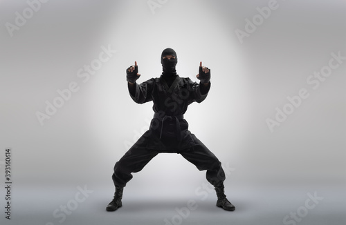 japanese ninja in black uniform, on grey background