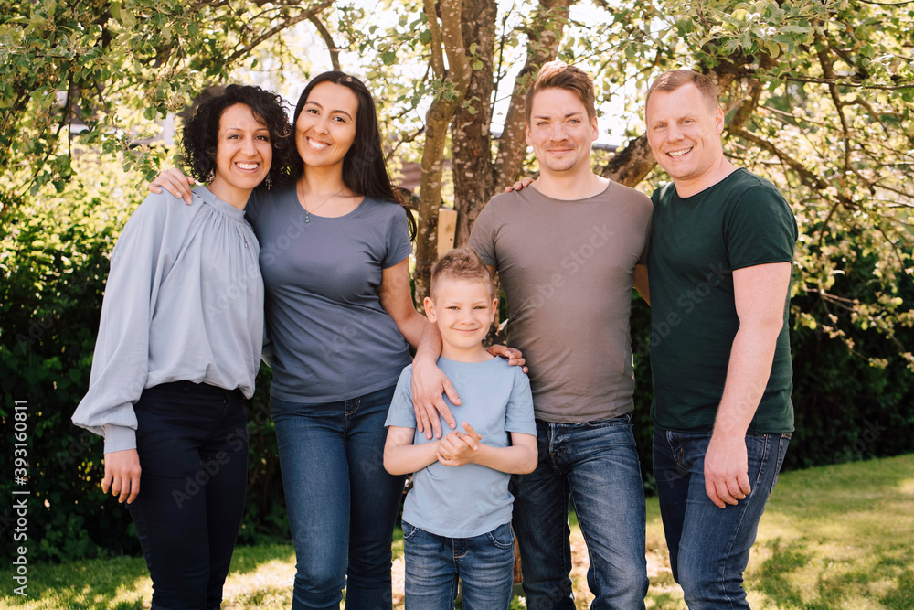 Portrait of smiling homosexual couples with son in backyard Portrait of smiling homosexual couples with son in backyard