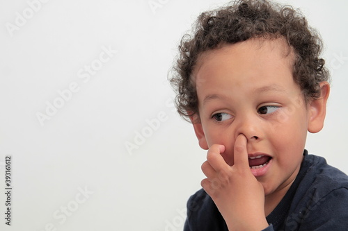 little boy picking his nose on white background stock photo