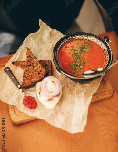 Tasty soup with tosts on wooden plate photo