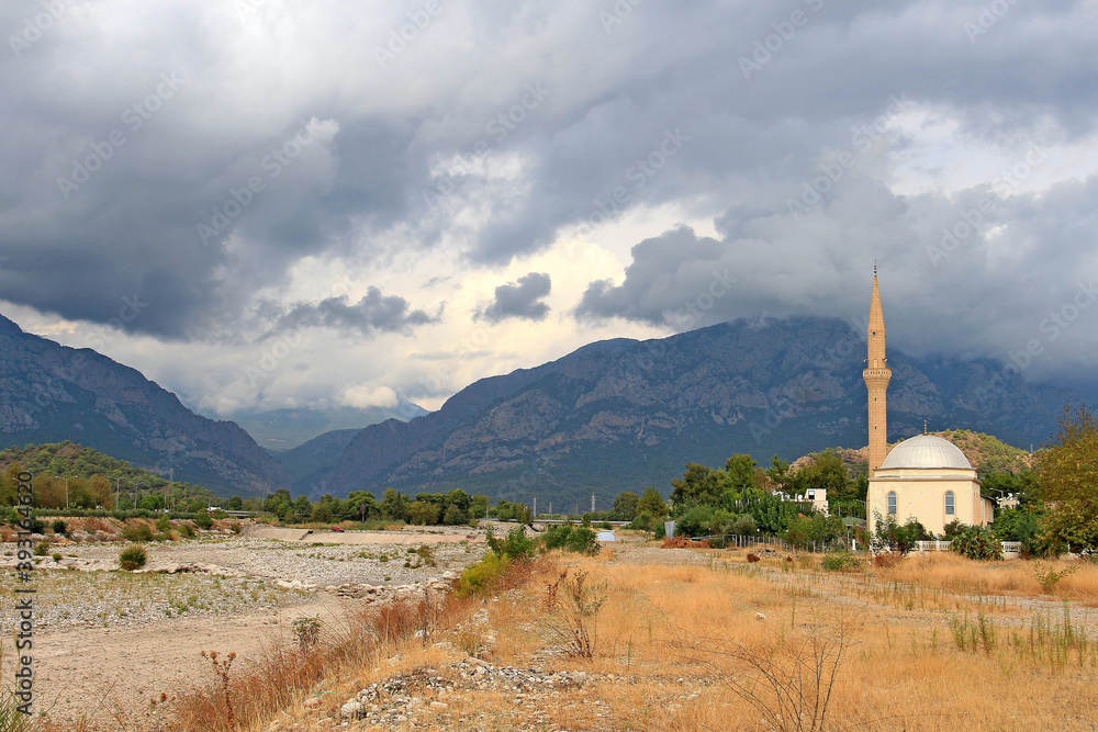 mosque with mountains and storm clouds in the background