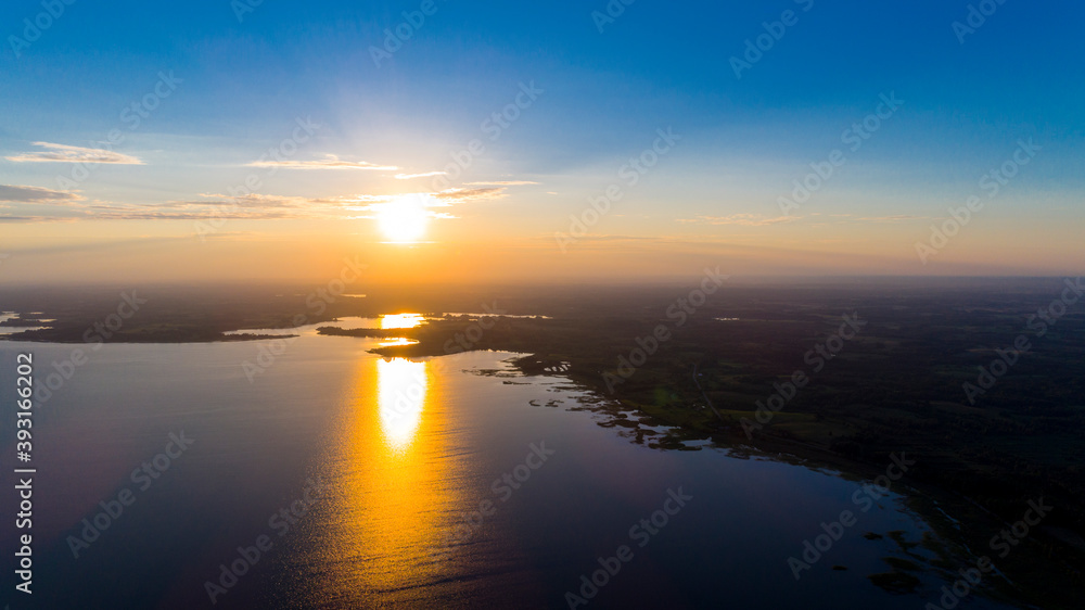 Scenic view from drone over sunset on big water and coastal line.