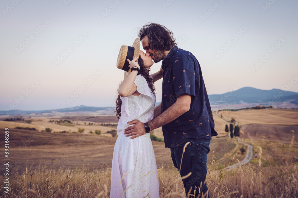a boy and a girl in love kissing at summer sunset in the middle of a wheat field a boy and a girl in love kissing at summer sunset in the middle of a wheat field