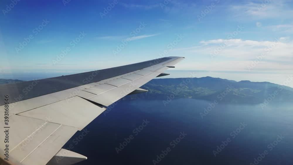plane wing with São Migel's island in the Azores on the background view from the window plane wing with São Migel's island in the Azores on the background view from the window