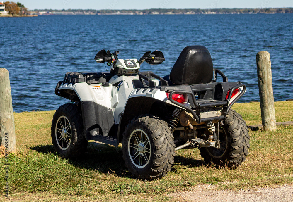 Fototapeta premium White ATV parked next to the waters edge in Conroe, TX.