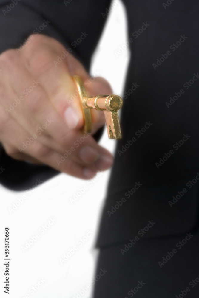 Close up of businessman holding an antique brass skeleton key.