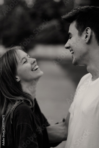 black and white portrait of smiling couple in puppy love in a park