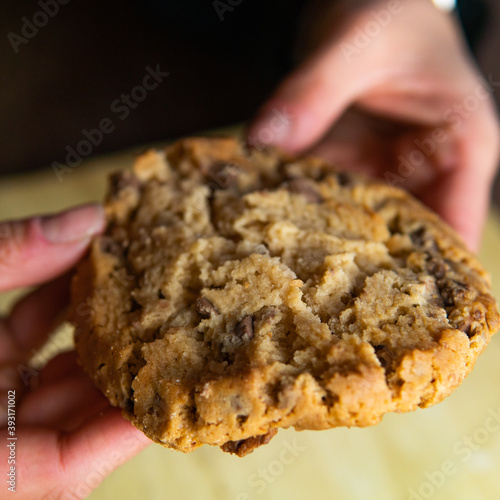 chocolate cookie split in two by a woman
