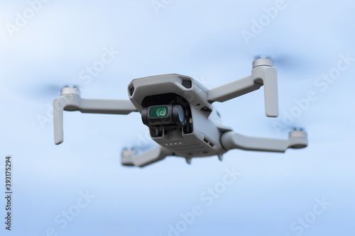 Gray mini quadcopter on a blue sky background
