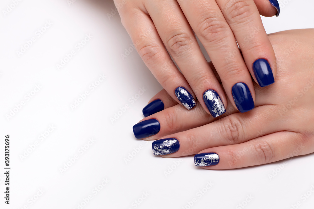 Dark blue manicure with silver matte foil under a business card on a white background with a large blanc on the right side on long square nails. Dark blue manicure with silver matte foil under a business card on a white background with a large blanc on the right side on long square nails.