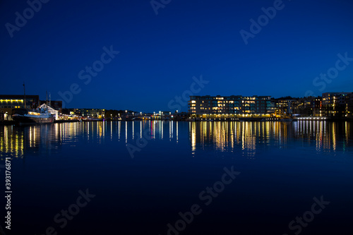 Night city lights reflecting on sea water. photo