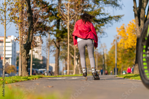 Active leisure. A sportive girl is rollerblading in an autumn park © Kate
