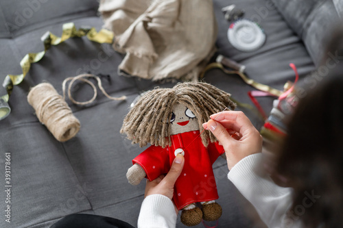 Handicraft is a fascinating hobby. The person sews dolls at their leisure