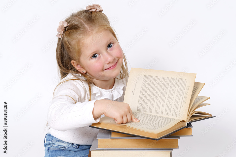 Portrait of a teenage girl who sits near books, reads and looks at the camera. Isolated over white background. Portrait of a teenage girl who sits near books, reads and looks at the camera. Isolated over white background.