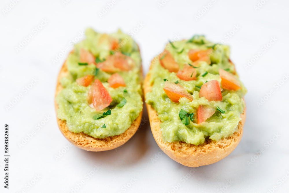 Guacamole toasts with tomato and parsley Guacamole toasts with tomato and parsley