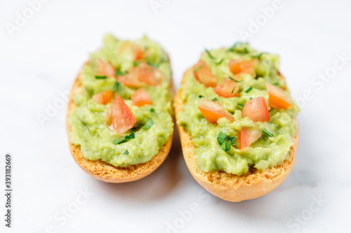 Guacamole toasts with tomato and parsley