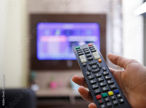 TV remote control In the hands that are pressing to change channels.