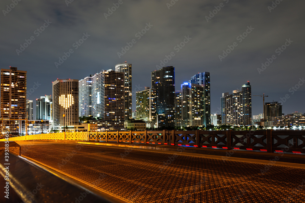 Obraz premium Miami, sunset panorama with colorful illuminated business and residential buildings and bridge on Biscayne Bay. Miami night downtown, city Florida.