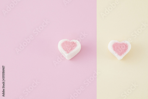 Top view closeup of colorful marshmallows isolated on a pinkand yellow background photo