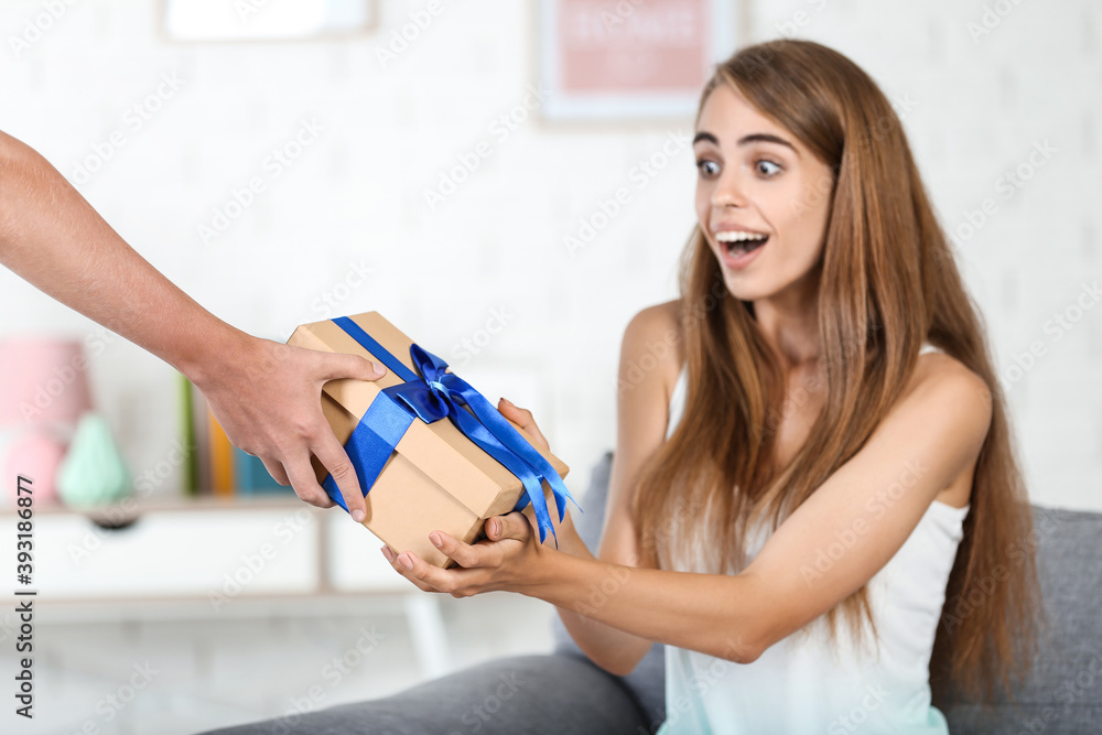 Surprised woman getting gift box from boyfriend Surprised woman getting gift box from boyfriend