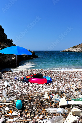 Dirty beach of Albania coast with girl sleeping in background