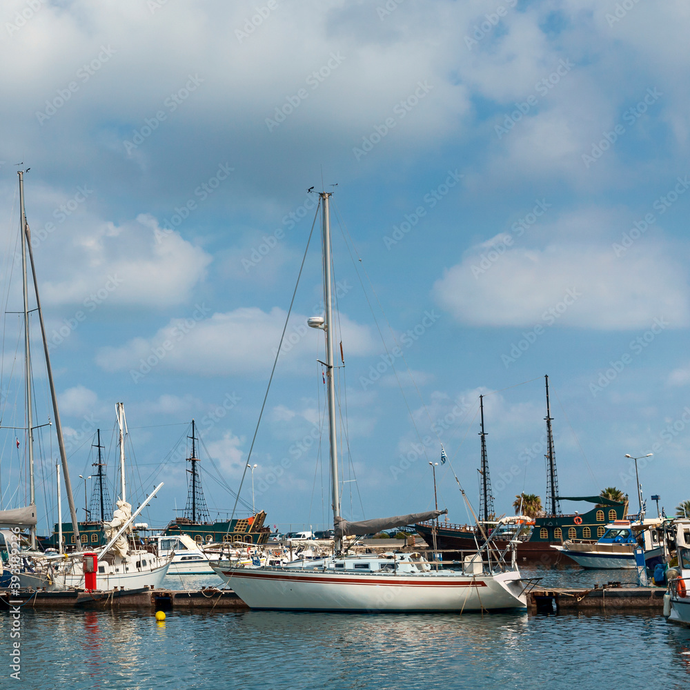 large and small sailboats in the harbor of the Greek city of Rethymno against the backdrop of a beautiful cloudy sky