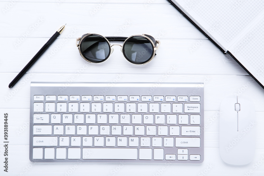 Computer keyboard with mouse and sunglasses on white wooden table Computer keyboard with mouse and sunglasses on white wooden table
