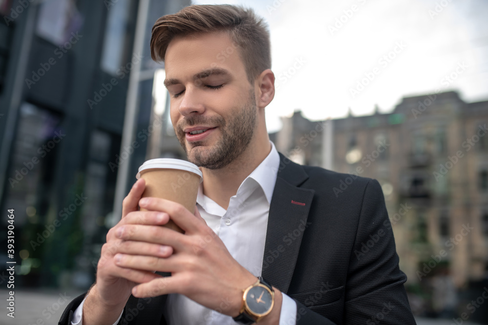 Elegant male businessman smelling coffee and looking relaxed Elegant male businessman smelling coffee and looking relaxed