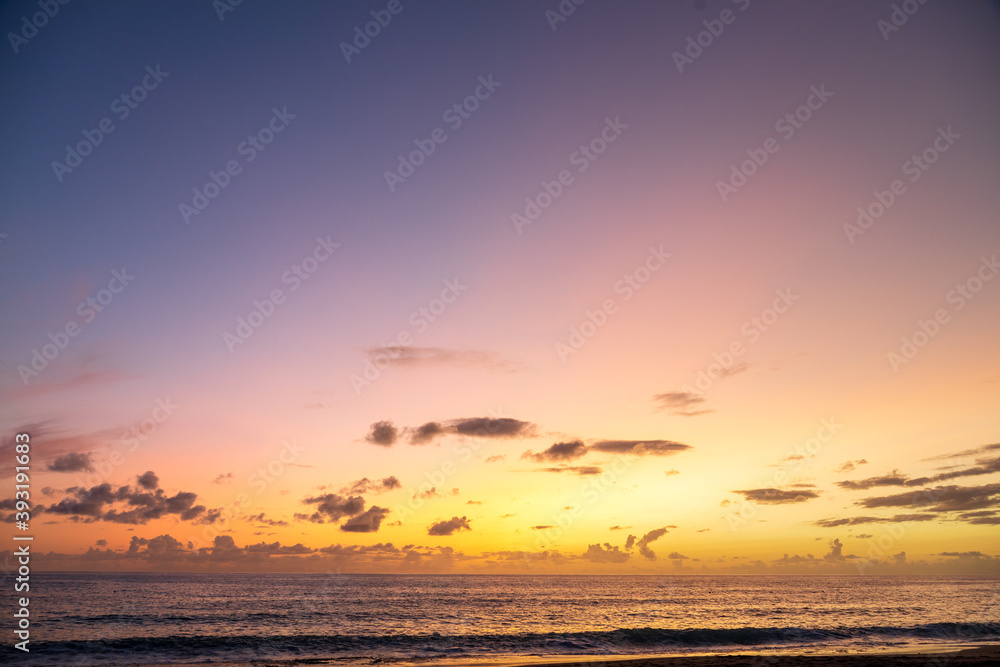 Dramatic sea shore sunset with sun setting down at the cloudy skyline with orange and vivid blues. Dramatic sea shore sunset with sun setting down at the cloudy skyline with orange and vivid blues.