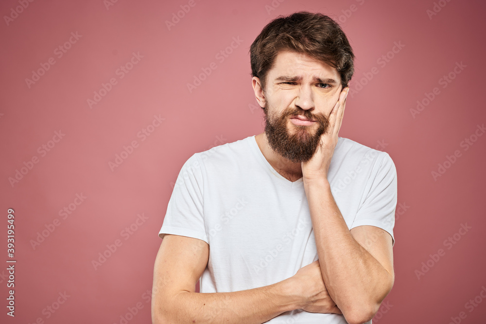 emotional man white t shirt sad facial expression pink background