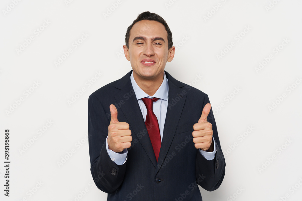 Business man in a classic suit shows a thumb on background. Business man in a classic suit shows a thumb on background.