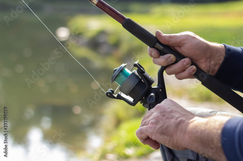 person fishing with a fishing rod and at the lake