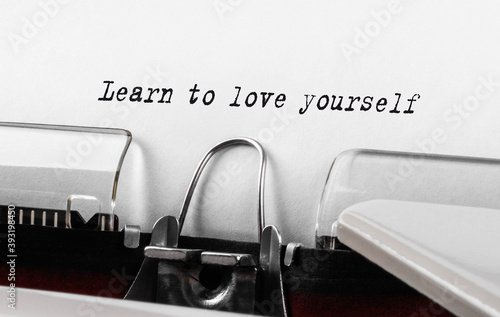 Text Learn to love yourself typed on retro typewriter