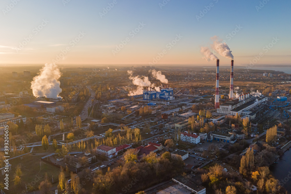 Aerial view of cityscape with industrial enterprises and emission of harmful smoke from the chimneys. Environmental pollution in big city