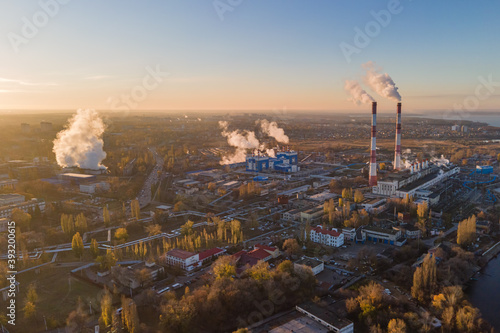 Aerial view of cityscape with industrial enterprises and emission of harmful smoke from the chimneys. Environmental pollution in big city