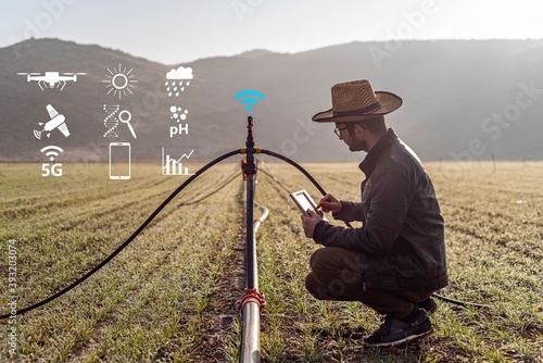Smart farming argriculture concept. Man hands holding a tablet on blurred organic farm as background. smart irrigation technology. american farmer photo