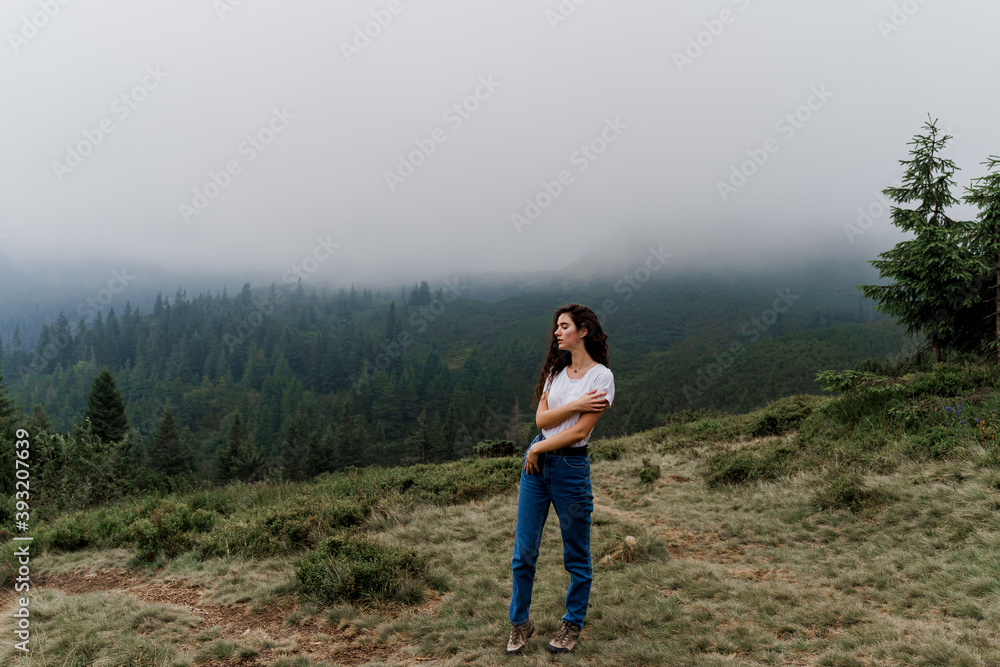 Girl is travelling in the mountains. Foggy day. Hiking and climbing up to the peak of the mountain. Beautiful nature of Ukraine. Girl is travelling in the mountains. Foggy day. Hiking and climbing up to the peak of the mountain. Beautiful nature of Ukraine.