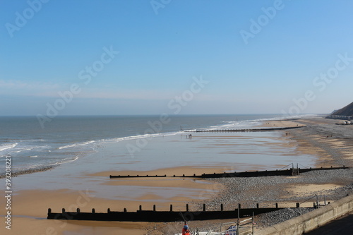 Beach, East England North Sea sandy beach view with a mans walking on the shore in distance, seagulls flying over, photo taken from the top © BC-Consulting