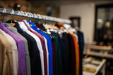 multicolored sweaters on a hanger in a clothing store