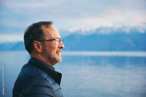 Fotografie Outdoor portrait of middle age man enjoying beautiful lake