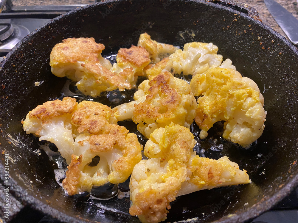 golden fried cauliflower in a skillet golden fried cauliflower in a skillet