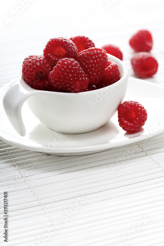 Raspberries in white cup - studio shot