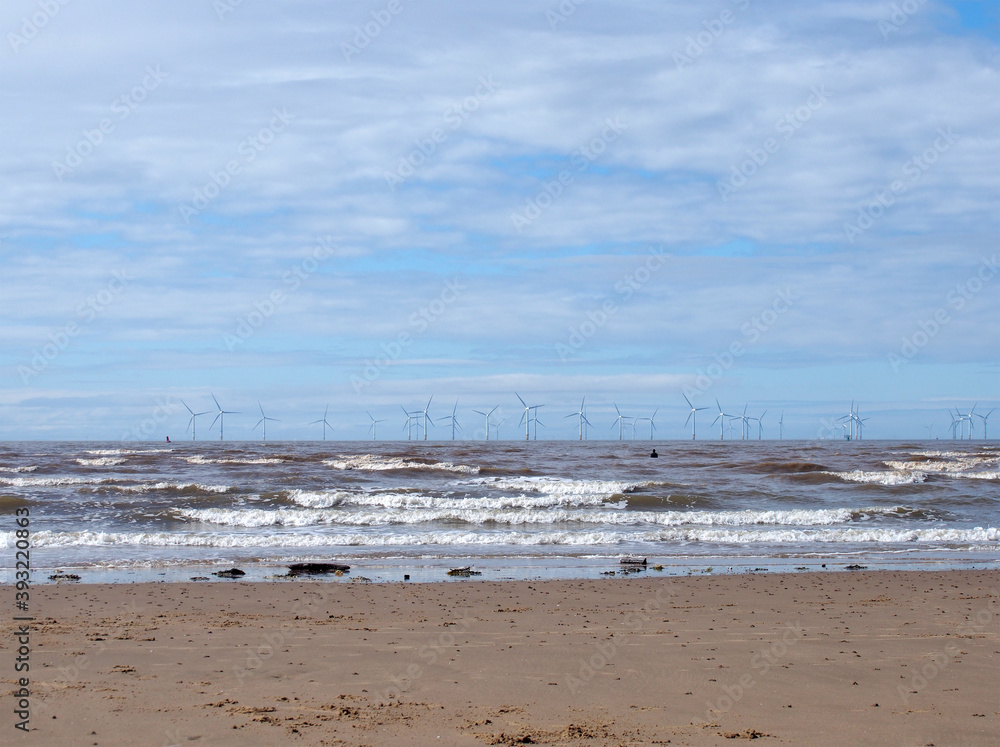the beach at blundell flats in southport with waves breaking on the beach and the wind turbines at burbo bank visible in the distance the beach at blundell flats in southport with waves breaking on the beach and the wind turbines at burbo bank visible in the distance