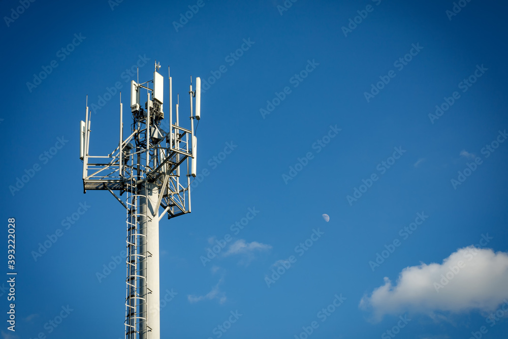 Telecommunication tower with 4G, 5G transmitters. Cellular base station with transmitter antennas on a telecommunication tower on against a blue sky - obrazy, fototapety, plakaty 