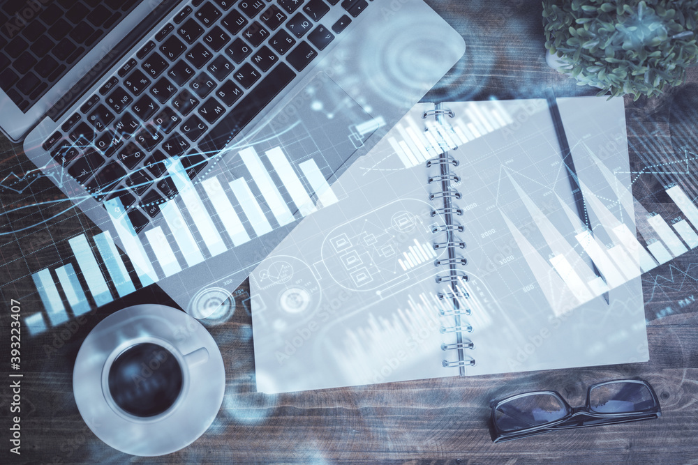 Financial market graph and top view computer on the desktop background. Double exposure. Investment concept. Financial market graph and top view computer on the desktop background. Double exposure. Investment concept.