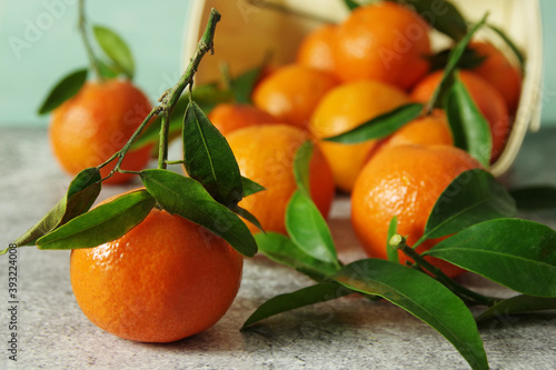 Fresh fragrant mandarins. Ripe juicy tangerines with green leaves on the table.