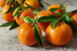 Fresh fragrant tangerines with green leaves on the table. Ripe juicy mandarins.